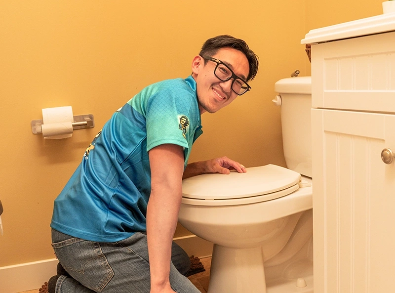 Piper the Plumber unclogging a sink in a Red Deer home